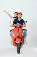 beeld van Aziatisch paar rijden scooter Aan wit achtergrond foto