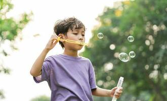 portret van Aziatisch jongen spelen blazen bubbels foto