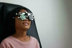 kind oog test in optisch op te slaan, kind oog controleren in kliniek foto