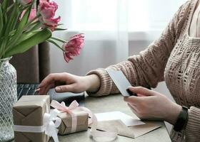 jong vrouw boodschappen doen online, sturen online betaling met credit kaart. kiezen cadeaus voor de vakantie online foto