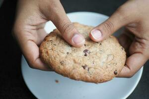 Dames hand- breken zoet koekjes foto