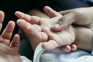 vader die de hand van het babykind vasthoudt, close-up. foto