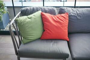 modern grijs sofa met kleurrijk kussens in leven kamer Bij huis foto