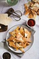 pittig chips met paprika en dille van tortilla Aan een bord top en verticaal visie foto