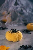 halloween spin Aan een handgemaakt gebreid pompoen Aan een spinneweb achtergrond verticaal visie foto