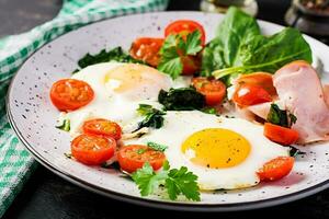 bord met een keto eetpatroon voedsel. gebakken ei, ham, spinazie, en tomaten. keto, paleo ontbijt. foto