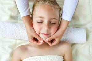 masseur aan het doen gezicht massage naar kind. foto