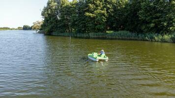 persoon zwemmen Aan de pedaal boot. meer activiteiten. meer landschap in de Woud. foto