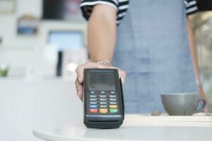 dichtbij omhoog hand- Holding de nfc betaling terminal. foto