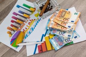 50 en 20 euro bankbiljetten asbak en sigaar met statistieken en pen