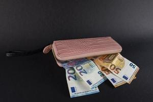 damesportemonnee bovenop eurobankbiljetten foto
