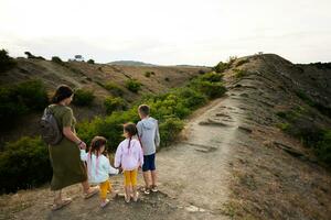 moeder met drie kinderen wandelen in de bergen Aan een zonnig zomer dag. kaap emine, zwart zee kust, bulgarije. foto