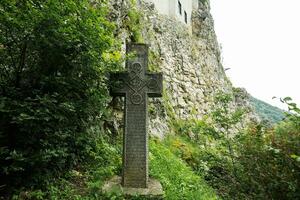 oud srone kroos tegen zemelen kasteel in Roemenië. dracula middeleeuws kasteel in Karpaten, transsylvanië. foto