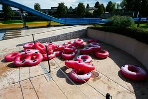 roze kleurrijk opblaasbaar ringen voor zwemmen in een water park Aan een zonnig dag. foto