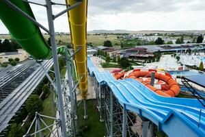 antenne visie van water park met blauw en geel water glijbaan Bij zomer dag. foto