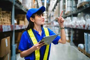 vrouw ingenieur controle voorraad in een groot magazijn voorraad. inspectie van invoer en export van goederen. foto