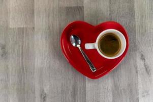 een kopje koffie met een hartvormig schoteltje