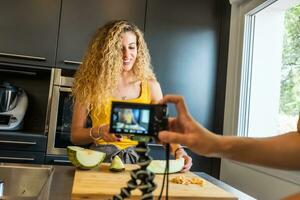 vrouw opname met een camera Leuk vinden een meloen snijder in een keuken foto