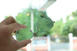 hand- Holding lenzenvloeistof, bril in hand, hand- Holding bril in optisch op te slaan foto