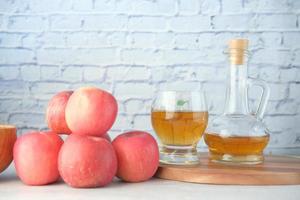 appelazijn in glazen fles met verse groene appel op tafel foto