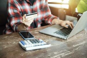 Aziatisch vrouw Holding plastic credit kaart en gebruik makend van laptop online boodschappen doen concept. toon afbeelding. foto