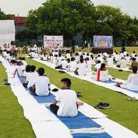 nieuw Delhi, Indië, juni 21, 2023 - groep yoga oefening sessie voor mensen Bij Yamuna sport- complex in Delhi Aan Internationale yoga dag, groot groep van volwassenen Bijwonen yoga klasse in krekel stadion foto