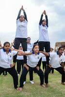 nieuw Delhi, Indië, juni 21, 2023 - groep yoga oefening sessie voor mensen Bij Yamuna sport- complex in Delhi Aan Internationale yoga dag, groot groep van volwassenen Bijwonen yoga klasse in krekel stadion foto