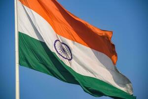 indiase vlag hoog op connaught plaats met trots in blauwe lucht, indiase vlag wapperen, indiase vlag op onafhankelijkheidsdag en republiek dag van india, tilt-up shot, wuivende indische vlag, har ghar tiranga foto