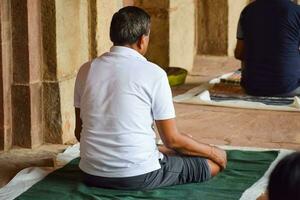 nieuw Delhi, Indië, mei 31 2023 - groep yoga oefening klasse voor mensen van verschillend leeftijd in lodhi tuin, Internationale yoga dag, groot groep van volwassenen Bijwonen een yoga klasse in park foto