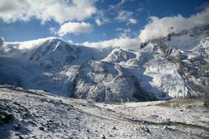 panoramisch visie van torenhoog bergen van gornergrat gedekt met sneeuw en wolken Aan een Doorzichtig dag. het is een beeld dat shows de schoonheid van Super goed natuur geschikt naar aantrekken toeristen naar bezoek ononderbroken foto