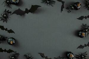 gelukkig halloween vlak leggen samenstelling met zwart pompoenen, spinnen en vleermuizen Aan donker achtergrond. vakantie concept. top visie. kopiëren ruimte. foto