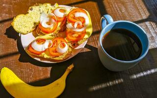 belegd broodje brood belegd broodje baguette tomaten uien met banaan en koffie. foto