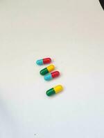 geïsoleerd wit foto van meerdere blauw en rood geneeskunde capsules en groen en geel capsules.