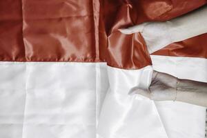 handen zetten samen Holding Indonesisch rood en wit vlag. Indonesië's onafhankelijkheid dag concept foto