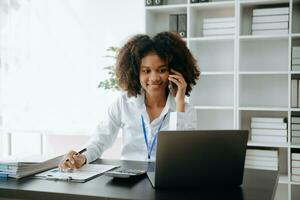 vrouw die smartphone gebruikt voor mobiele betalingen online winkelen, omni-channel, zittend op tafel, virtuele pictogrammen grafische interface-scherm in ochtendlicht foto