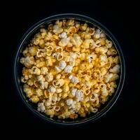 popcorn in een kom Aan een zwart achtergrond. top visie. foto