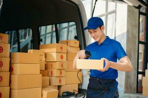 glimlachen levering Mens staand in voorkant van zijn busje met Holding doos en tablet levering huis en Verzending foto