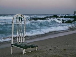 oude stoel op een verlaten strand. sokcho stad. Zuid-Korea foto