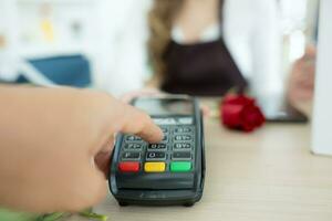 detailopname van een vrouw betalen met credit kaart in bloemen winkel foto