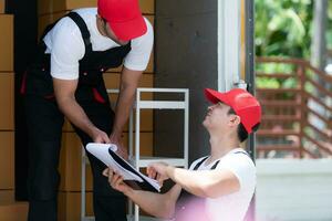 levering Mens in rood pet en uniform leveren pakket naar ontvanger - koerier onderhoud concept foto