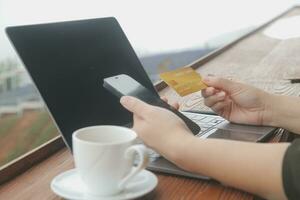 online betaling, jong vrouw Holding credit kaart en aanraken Aan smartphone scherm, kopiëren ruimte foto