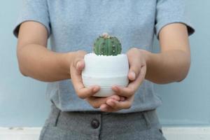 close-up beeld van een vrouw die een cactus vasthoudt foto