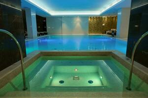 thermisch zwemmen zwembad met onderwater- verlichtingen en waterval in luxe hotel spa centrum foto