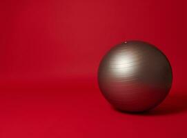 zilver fit bal Aan een helder rood achtergrond met kopiëren ruimte voor reclame tekst. sport, fitheid, sport- uitrusting concept foto