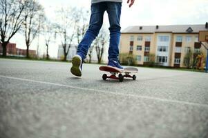 visie van de terug van skateboarder poten. kind rijden skateboard buitenshuis. concept van vrije tijd werkzaamheid, sport, extreem, hobby. foto