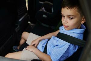 een tiener- jongen vervelend stoel riemen reist door auto in een beschermend kind booster auto stoel. op reis veilig met kinderen. foto