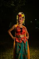 een Javaans danser poses met scherp ogen en een gouden kostuum Aan stadium foto
