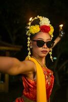 een Javaans danser dansen heel vakkundig terwijl vervelend zonnebril Aan haar ogen en heel mooi gelaats bedenken foto