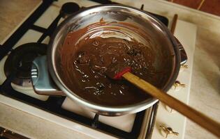 verwarming en smelten chocola in een water bad voordat temperen het voor voorbereidingen treffen handgemaakt chocola desserts foto