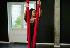 mooi jong vrouw, yoga instructeur beoefenen vlieg yoga in de Sportschool. foto